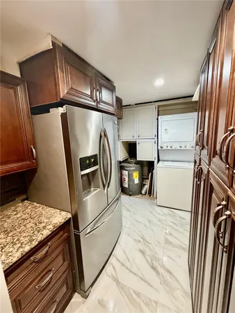 a kitchen with stainless steel appliances granite countertop a refrigerator a stove and a sink