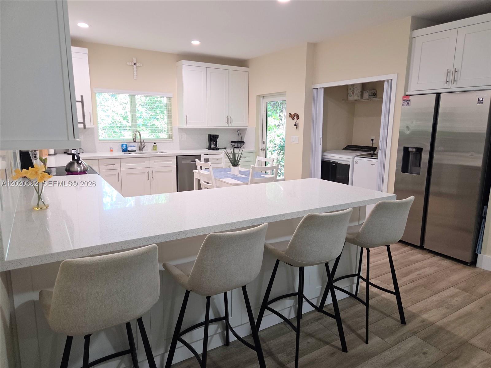 11 Pompano Avenue, Unit 11 Key Largo, FL 33037 - Photo 4 of 15 a kitchen with stainless steel appliances granite countertop a table chairs refrigerator and window