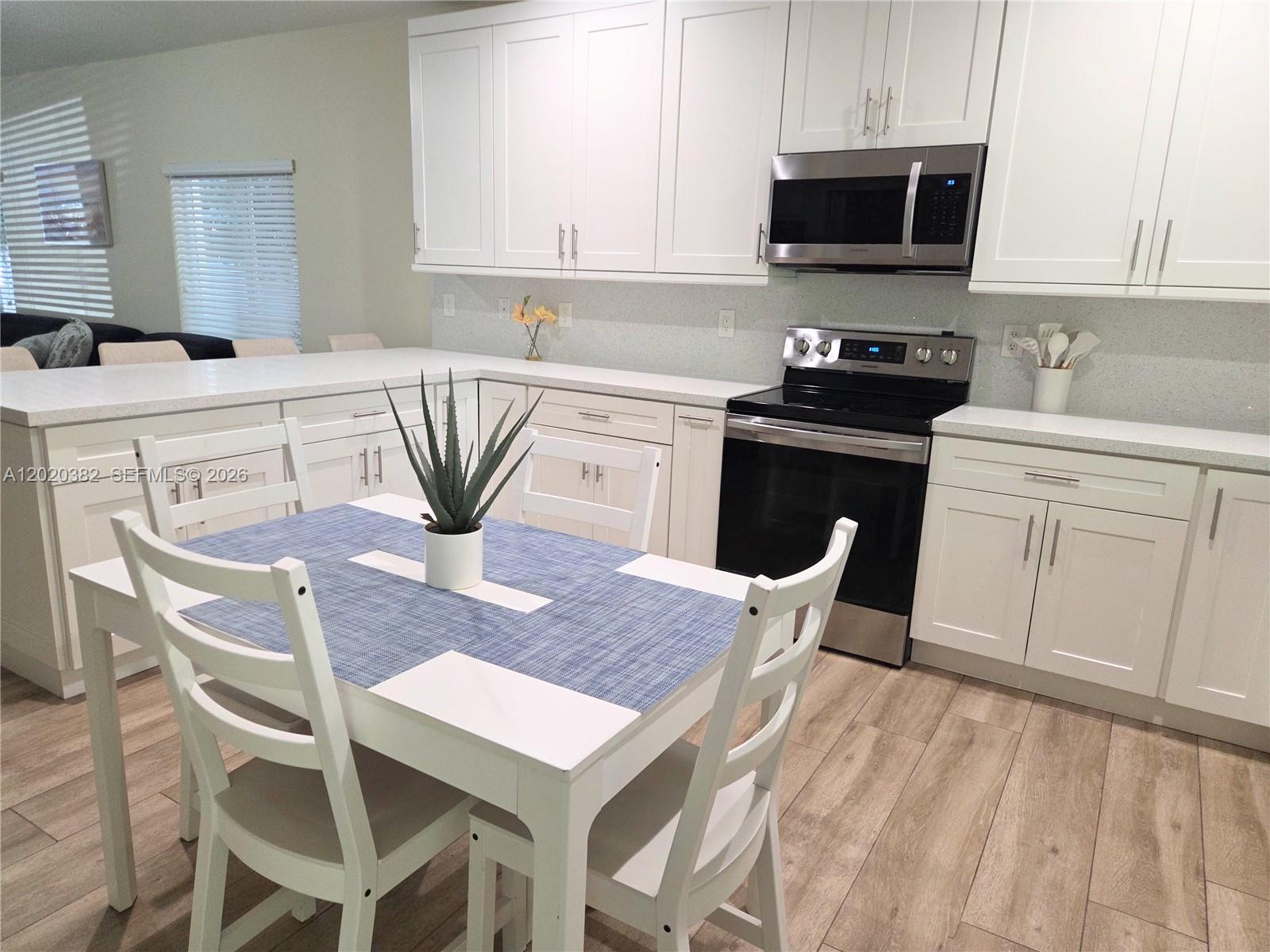 11 Pompano Avenue, Unit 11 Key Largo, FL 33037 - Photo 5 of 15 a kitchen with stainless steel appliances a kitchen island a stove a table and chairs