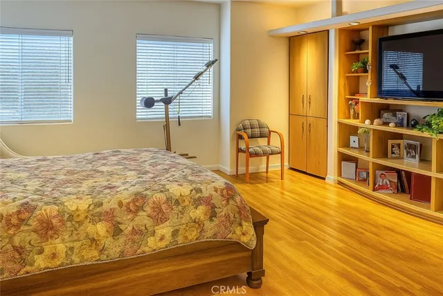 a bedroom with a bed and wooden floor