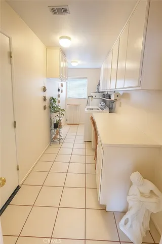 a view of a kitchen with kitchen island a sink a counter and a view of living room