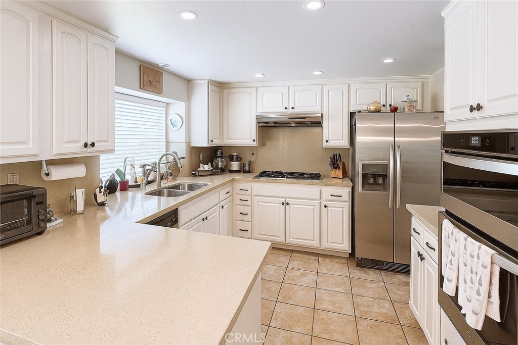 25463 Hardy Place Stevenson Ranch, CA 91381 - Photo 4 of 21 a kitchen with granite countertop a sink a counter top space stainless steel appliances and cabinets