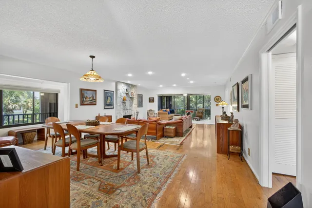 a dining room with furniture a chandelier and wooden floor
