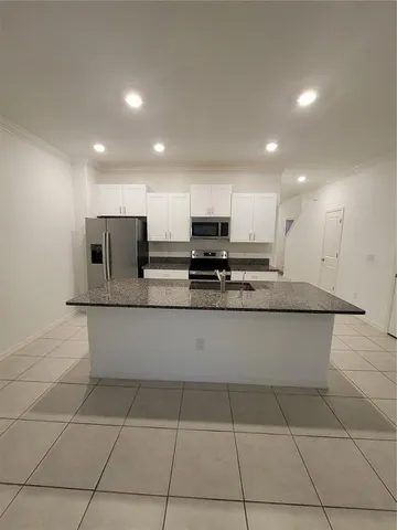 a view of kitchen with granite countertop lots of counter top space and cabinets