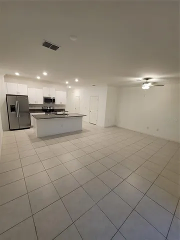a large kitchen with stainless steel appliances lots of white cabinets