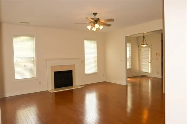 a view of a hallway with wooden floor and a bathroom