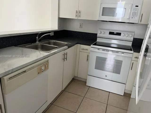 a kitchen with a stove and white cabinets