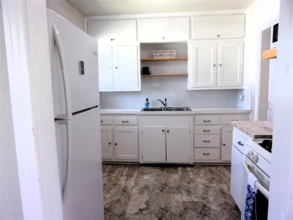 a kitchen with stainless steel appliances a refrigerator sink and cabinets