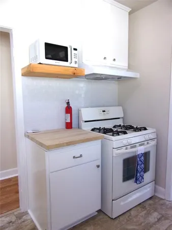 a kitchen with a stove and white cabinets