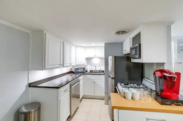 a kitchen with stainless steel appliances granite countertop a sink refrigerator and microwave