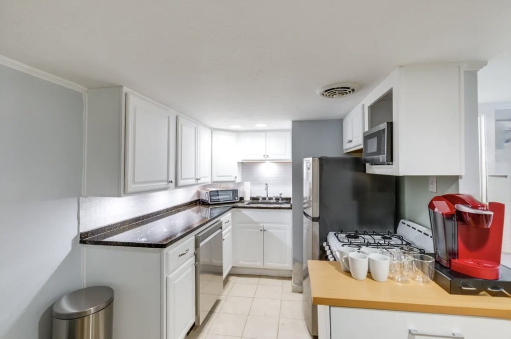 8 Franklin Street, Unit 19 Marblehead, MA 01945 - Photo 2 of 15 a kitchen with stainless steel appliances granite countertop a sink refrigerator and microwave