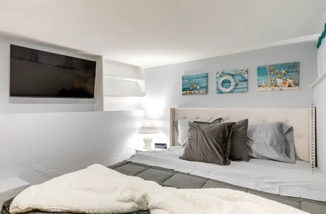 a bedroom with a bed and a flat screen tv