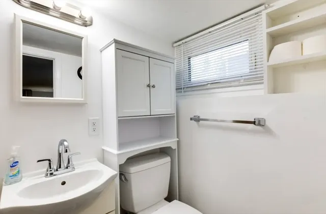 a bathroom with a sink toilet and mirror