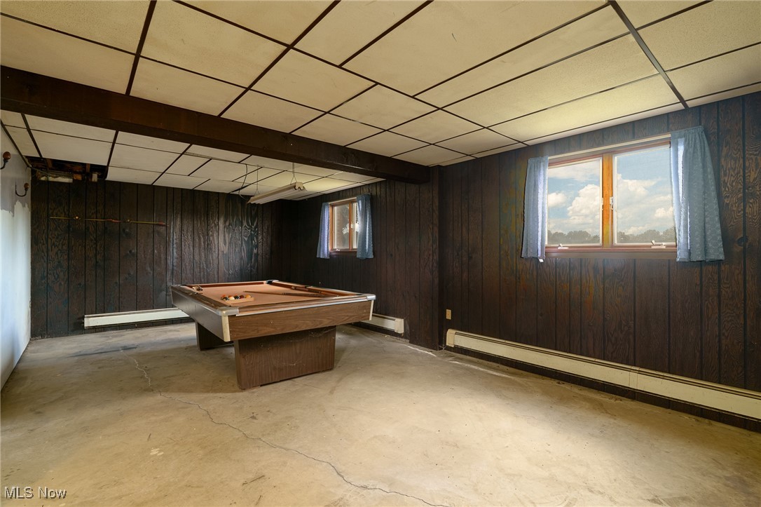 6747 Giddings Road Rootstown, OH 44272 - Photo 21 of 39 Recreation room with a brick fireplace, concrete floors, billiards table, a baseboard radiator, and wood walls