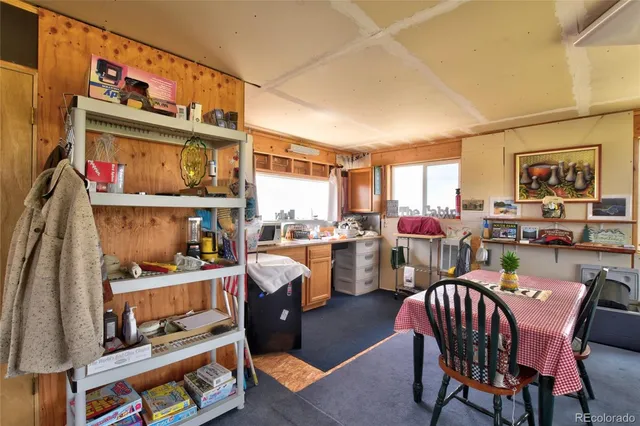 a dining room with stainless steel appliances a dining table and chairs with wooden floor