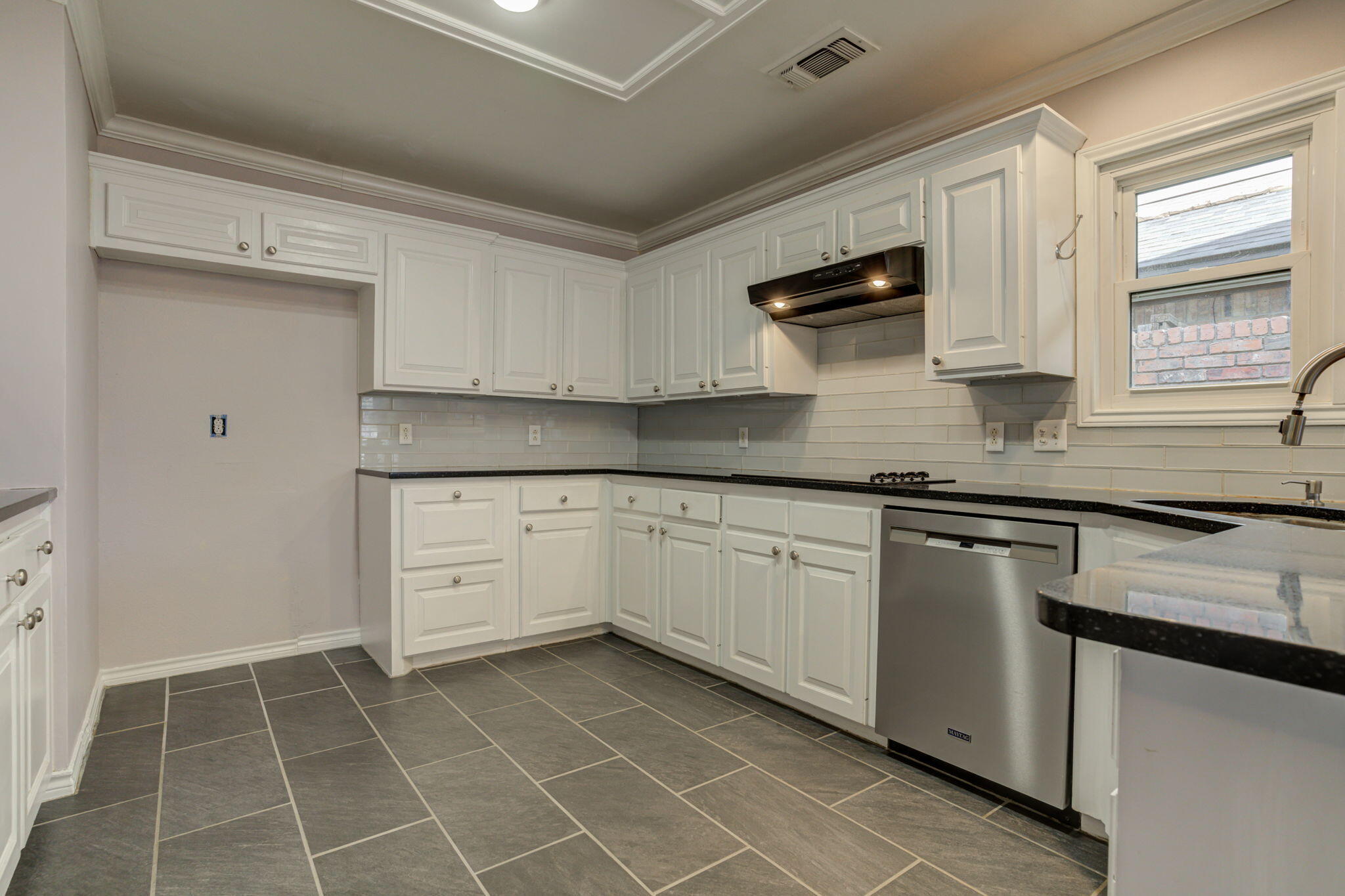 5107 1st Place Lubbock, TX 79416 - Photo 9 of 67 a kitchen with granite countertop white cabinets stainless steel appliances and a sink
