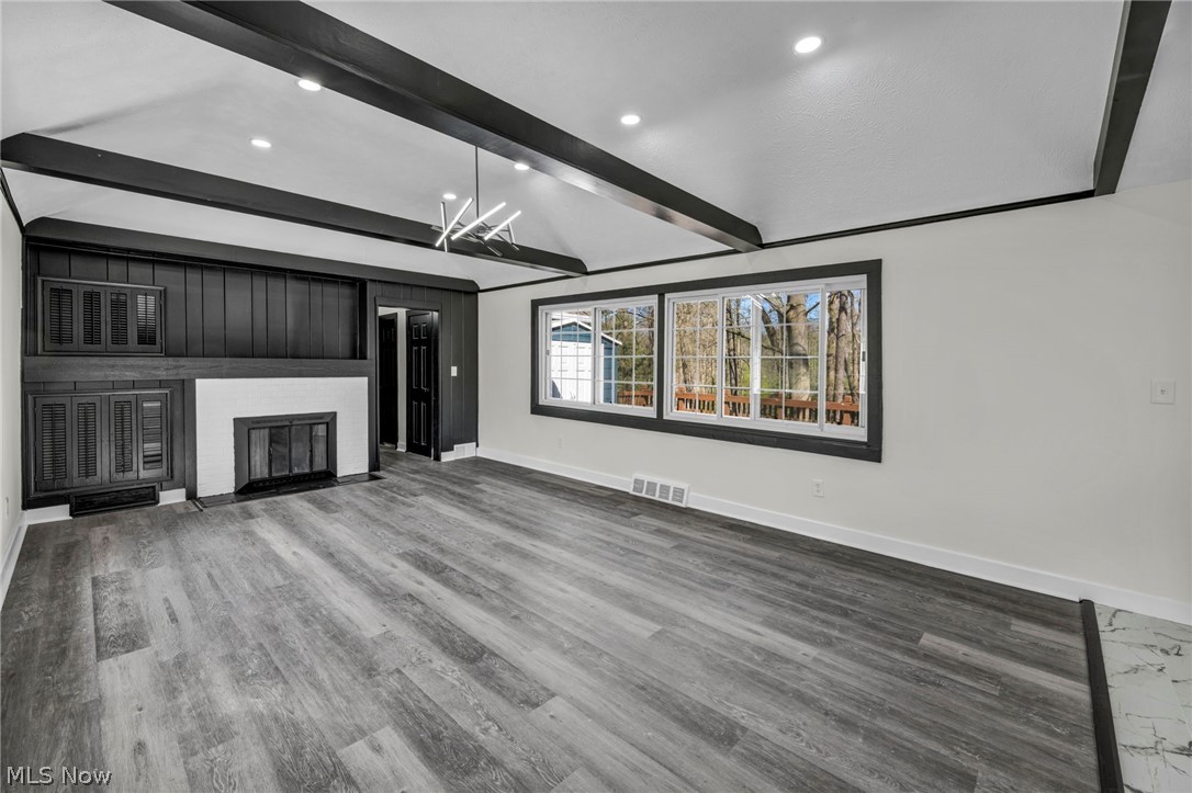 7339 River Road Olmsted Falls, OH 44138 - Photo 5 of 45 Vaulted ceiling with exposed black beams, recessed lighting, and a modern linear chandelier