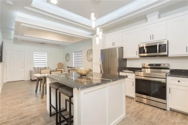 a kitchen with stainless steel appliances granite countertop a stove microwave and refrigerator