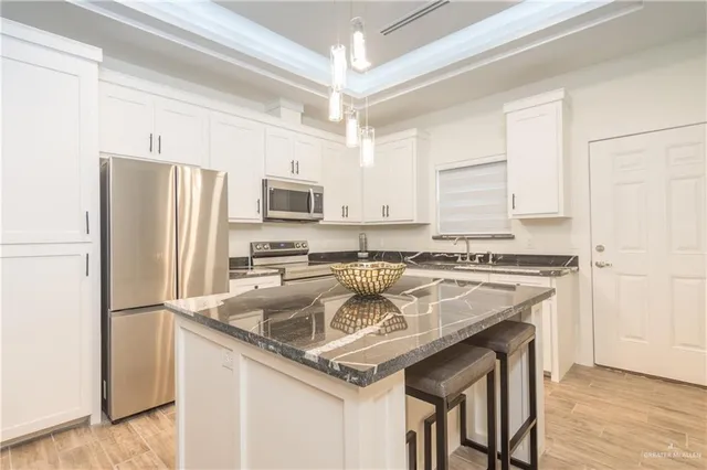 a kitchen with stainless steel appliances granite countertop a stove refrigerator sink and microwave