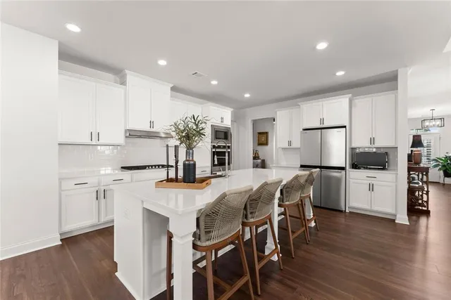 a open kitchen with sink a stove and chairs