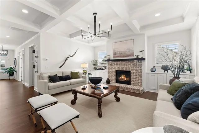 a living room with furniture a fireplace and a chandelier