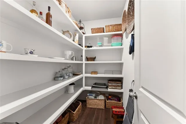 a view of a white house with a big yard and potted plants