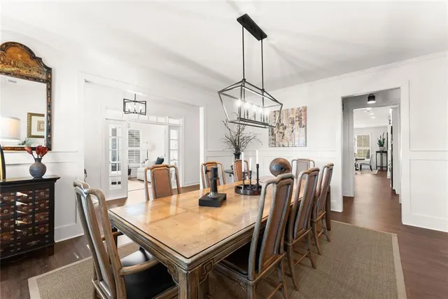 a view of a dining room and livingroom with furniture wooden floor a chandelier