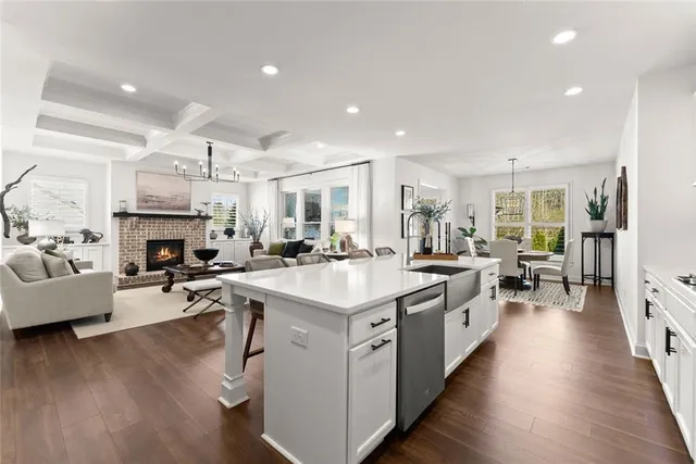 a kitchen with stainless steel appliances kitchen island granite countertop a dining table chairs and wooden floor