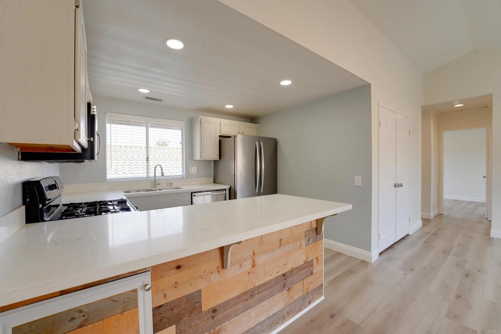1354 Palomar Place Vista, CA 92084 - Photo 15 of 37 a kitchen with stainless steel appliances granite countertop a sink a stove a refrigerator a counter top space and cabinets