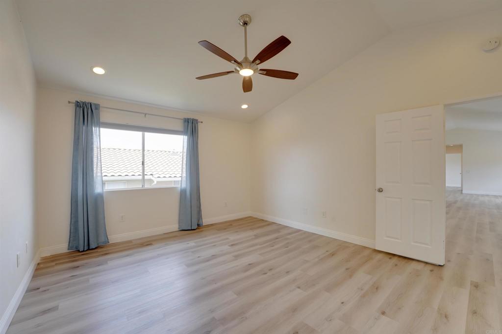 1354 Palomar Place Vista, CA 92084 - Photo 21 of 37 an empty room with wooden floor a ceiling fan and windows