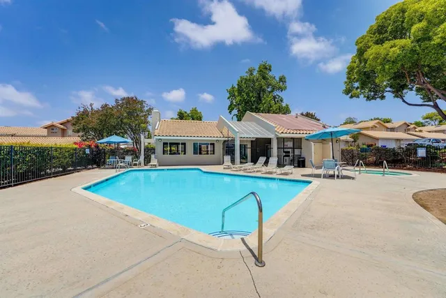 an aerial view of a house with swimming pool and glass top table and chairs