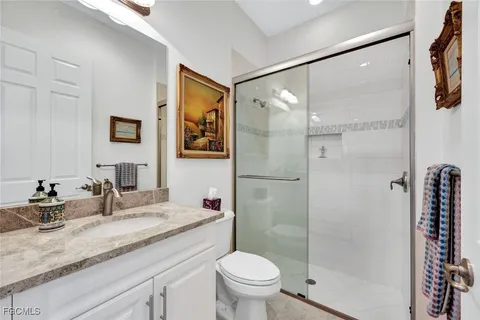 a bathroom with a granite countertop sink toilet and shower