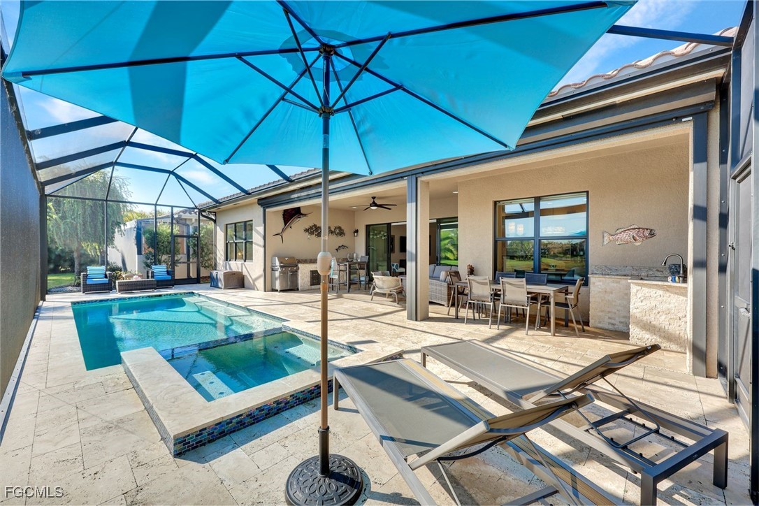11725 Stonecreek Circle Fort Myers, FL 33913 - Photo 30 of 40 a patio with a table and chairs under an umbrella