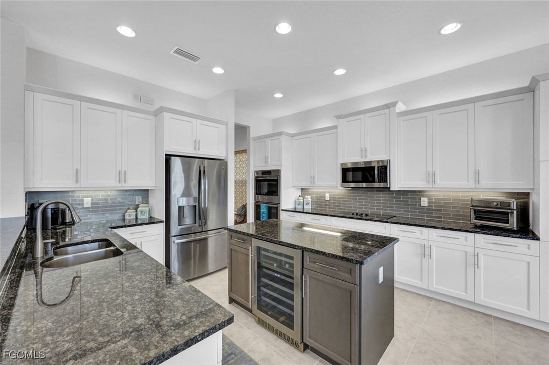 11725 Stonecreek Circle Fort Myers, FL 33913 - Photo 8 of 40 a kitchen with stainless steel appliances granite countertop a sink stove and refrigerator