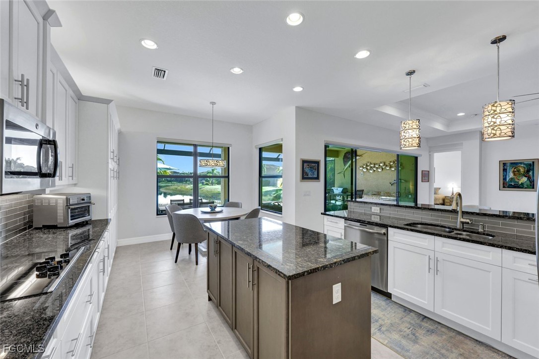 11725 Stonecreek Circle Fort Myers, FL 33913 - Photo 9 of 40 a kitchen with counter space sink stove and chairs