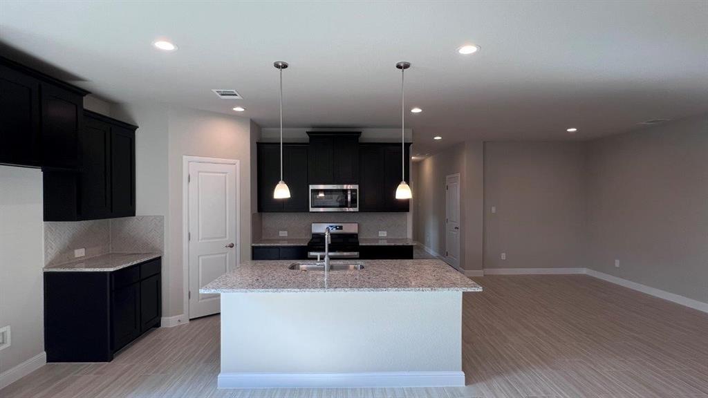 125 Medina Lane Rhome, TX 76078 - Photo 19 of 21 a large kitchen with stainless steel appliances a large counter top a stove and a refrigerator
