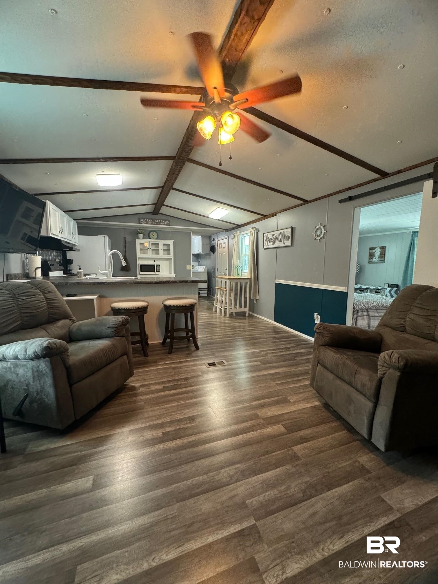 1420 Ridgewood Circle Lillian, AL 36549 - Photo 5 of 41 Living room with dark wood-type flooring, ceiling fan, lofted ceiling with beams, and a textured ceiling