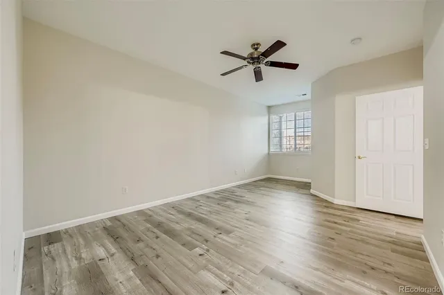 a view of empty room with wooden floor and window
