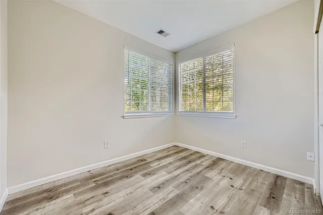 a view of a room with wooden floor and windows