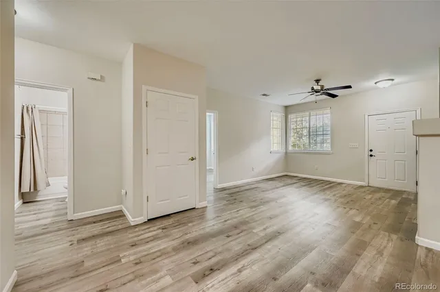 an empty room with wooden floor and windows