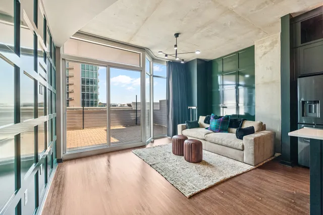 a living room with furniture and a floor to ceiling window