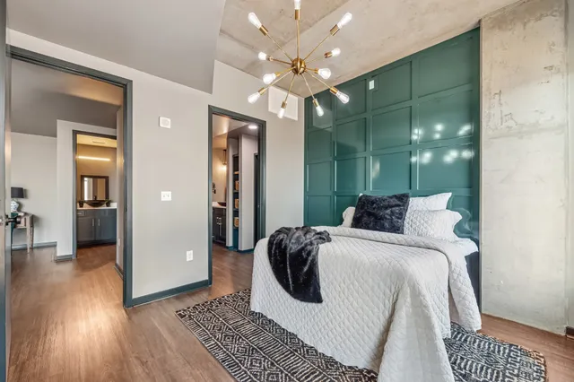 a spacious bedroom with a bed a mirror and lamp