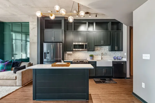 a kitchen with a sink and a stove with wooden floor