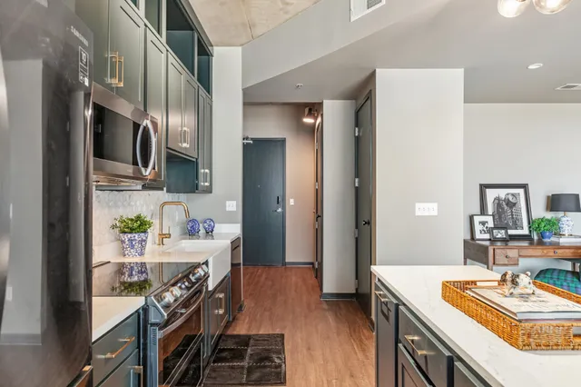 a kitchen that has a lot of cabinets a sink and wooden floor
