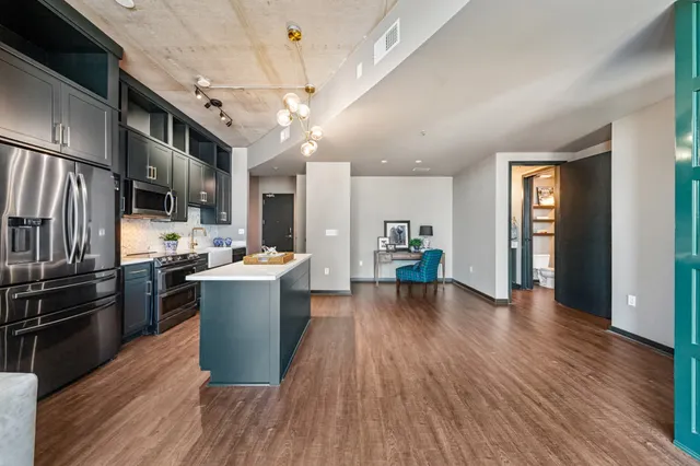 a kitchen with a refrigerator and wooden floor