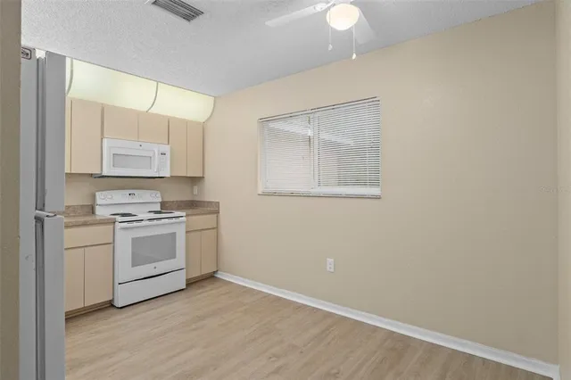 a kitchen with a stove cabinets and wooden floor