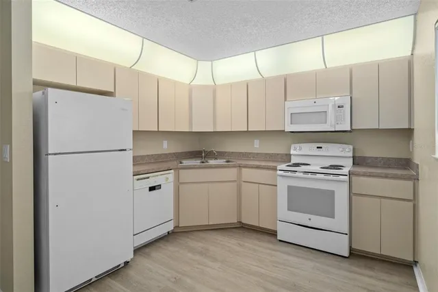 a kitchen with cabinets appliances a sink and a window