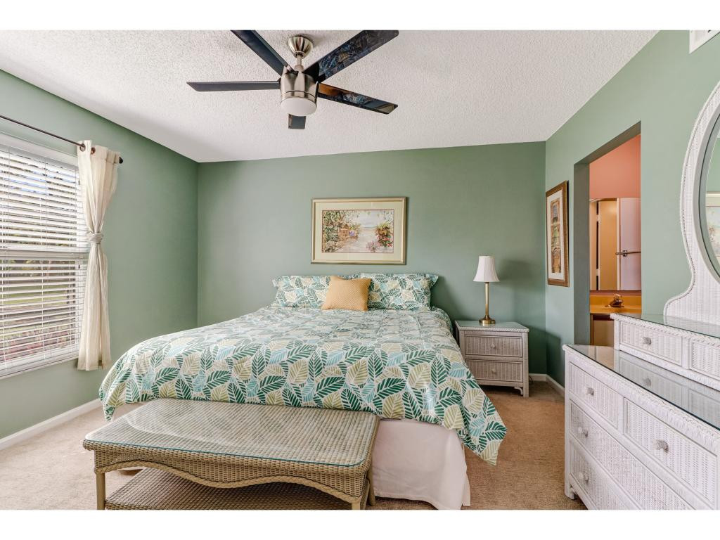 5739 Whitaker Road, Unit 103 Naples, FL 34112 - Photo 13 of 18 a bedroom with a bed a dresser next to a window