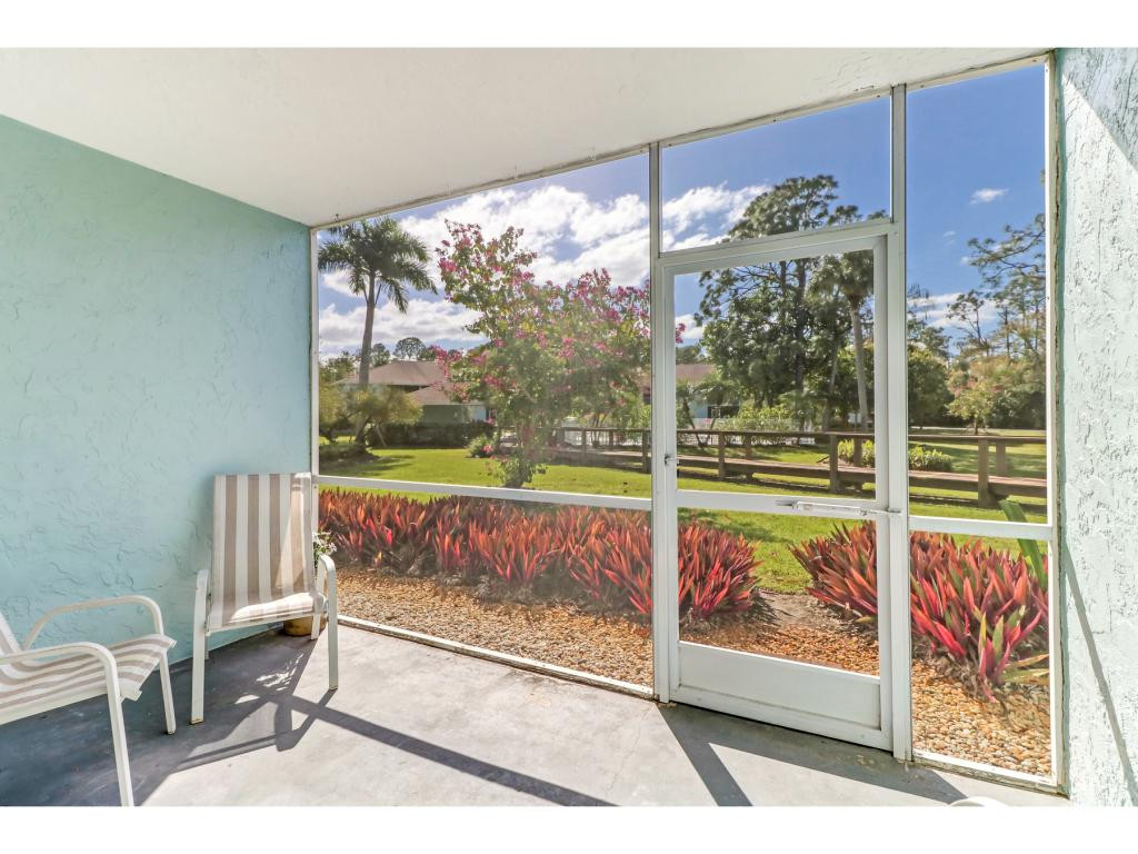 5739 Whitaker Road, Unit 103 Naples, FL 34112 - Photo 16 of 18 a view of a floor to ceiling window with wooden floor