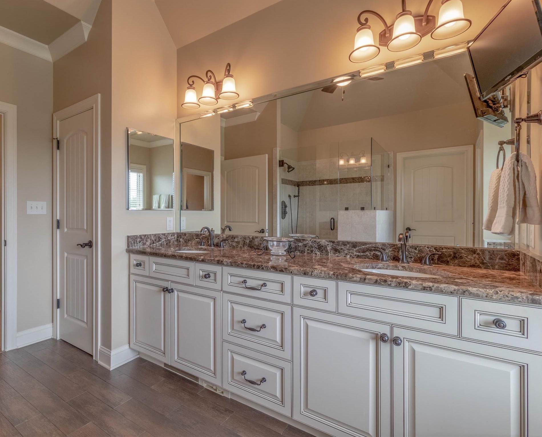 2687 Gunn Road Adams, TN 37010 - Photo 12 of 30 a bathroom with a granite countertop sink a large mirror and a vanity